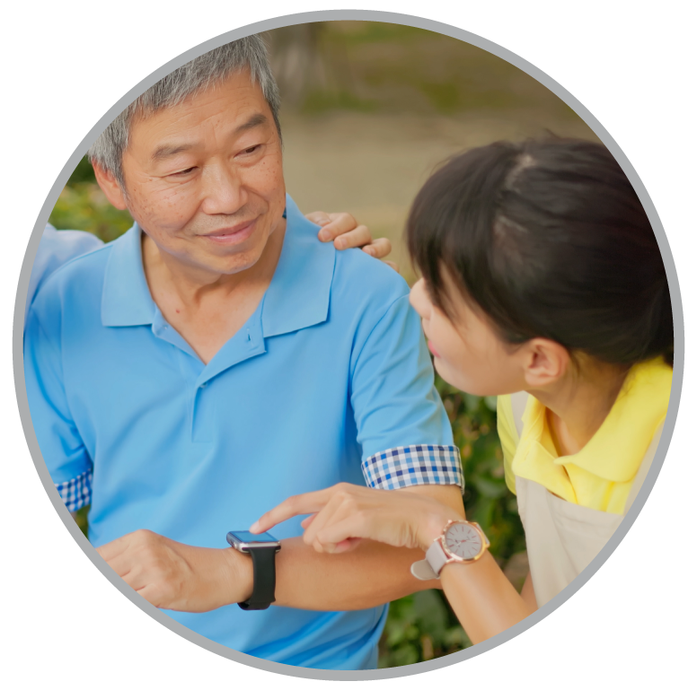 An older man in a blue shirt and watch with a woman looking at him with a yellow shirt.